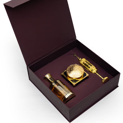 Gold perfume bottle and atomizer set in an open brown box on a white background