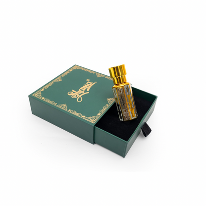Perfume bottle with gold cap in a green box on a white background